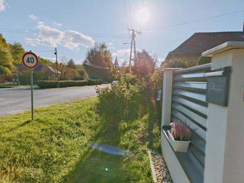 a house on the side of a road with a speed limit sign at Búj-Lak Vendégház in Zalaszentmárton