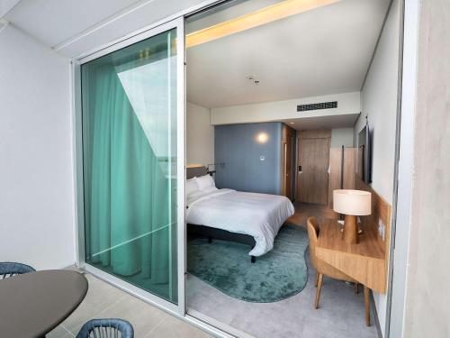 a room with a bed and a glass door leading to a bedroom at Novotel Recife Marina in Recife