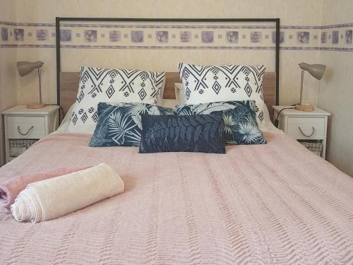 - un lit avec une couette et des oreillers roses dans l'établissement Maison EL Marielle, à Vierzon