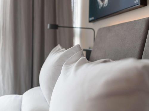 a person laying on a bed with a pillow at Novotel Recife Marina in Recife