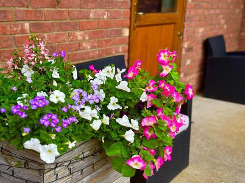 a basket of flowers sitting on a table at Bluebell Cottage - Cedar Park in Grimsby