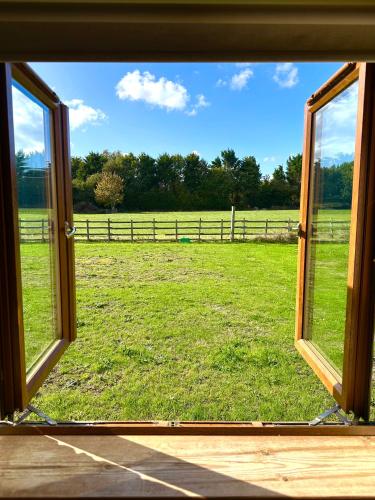 an open window with a view of a field at Bluebell Cottage - Cedar Park in Grimsby