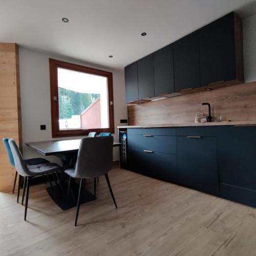 une cuisine avec une table et des chaises et une fenêtre dans l'établissement Hearth of Courchevel - La Tania, à Courchevel