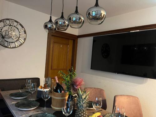 a dining room table with wine glasses and a clock on the wall at Apart TYROL in Finkenberg