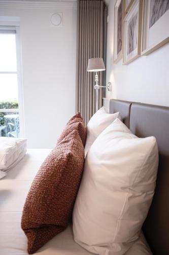two pillows sitting on a bed in a bedroom at Fakkelgaarden Hotel & Restaurant in Kruså