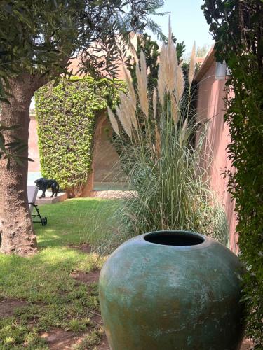 a large green vase sitting in a yard at Villa #1 ‘Rosalie’ in Marrakech