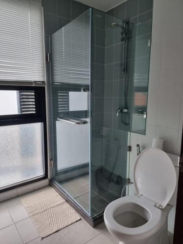 a bathroom with a toilet and a glass shower at Néo Condo Jomtien Pattaya in Jomtien Beach