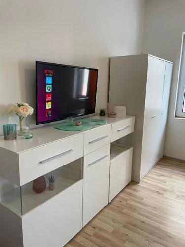 a white entertainment center with a flat screen tv at Gemütliches City Apartment in Recklinghausen