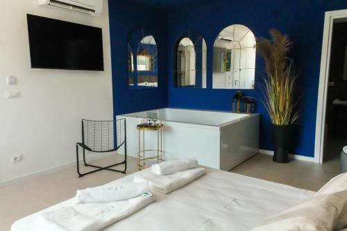 un salon avec un lit blanc et un mur bleu dans l'établissement Kāma, à Bari Palese