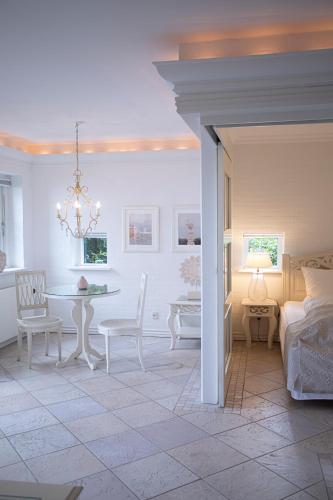 a living room with a table and a bedroom at Fakkelgaarden Hotel & Restaurant in Kruså