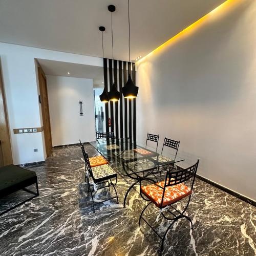 a dining room with a glass table and chairs at Supérieur Suite Balima B25 in Rabat