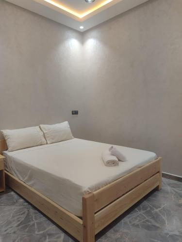 a bed in a room with a white wall at Sea Breeze in Imsouane