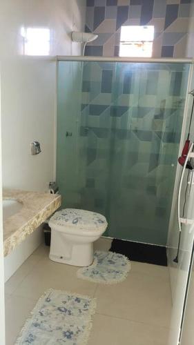 a bathroom with a toilet and a glass shower at Casa aconchegante em Caravelas Abrolhos BA in Caravellas