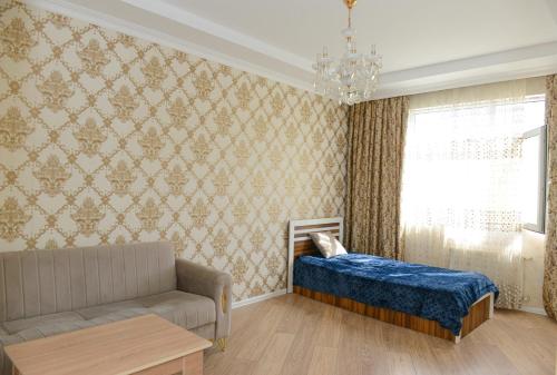 a living room with a couch and a bed and a window at Idea Park Apartment in Baku
