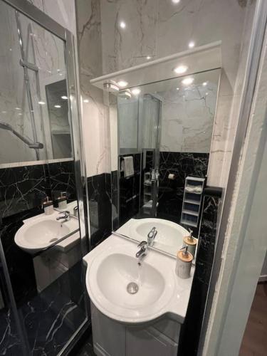 une salle de bain avec deux lavabos et un miroir dans l'établissement Appartement Gare-Centre-Rouen, à Rouen
