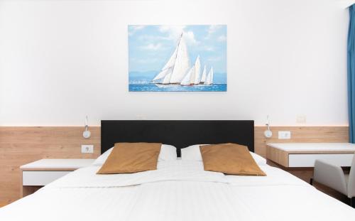 een slaapkamer met een groot wit bed met twee witte zeilboten bij Garden Palace - Vitamin Sea Appartment with Teracce in Umag