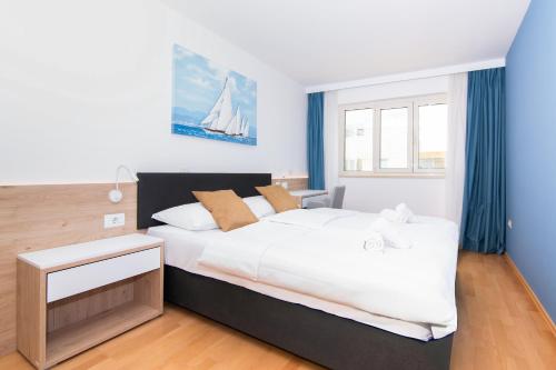 een slaapkamer met een groot wit bed en een raam bij Garden Palace - Vitamin Sea Appartment with Teracce in Umag