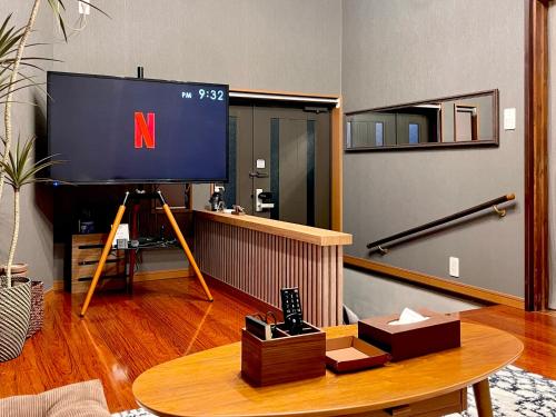 a living room with a tv and a table at ハルノヒハウス-春日部の民泊- Spring Day House in Kasukabe in Kasukabe