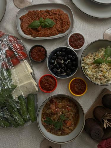 ein Tisch mit Tellern und Schüsseln voller Essen in der Unterkunft FAliyyas Village in Meiningen