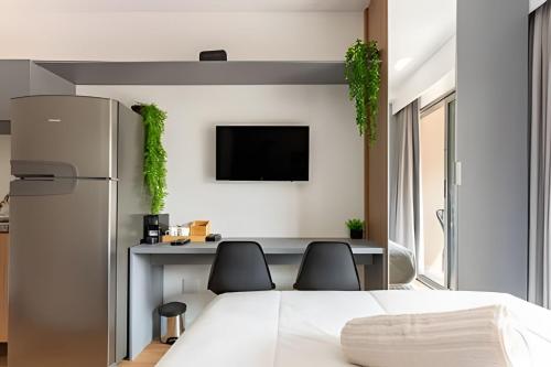 a bedroom with a bed and two chairs at Nik Perdizes in Sao Paulo