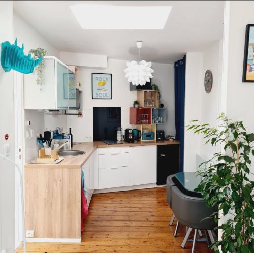 une cuisine avec des placards blancs, une table et un bureau dans l'établissement L' effet mer, à Dunkerque