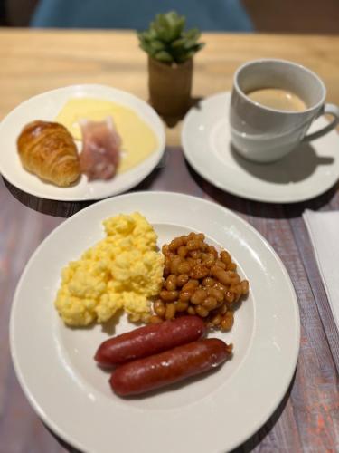 a table with two plates of food and a cup of coffee at Hotel Douglas in Puteaux