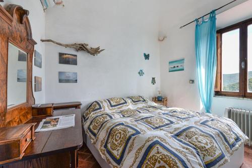a bedroom with a bed with a dresser and a desk at Nadine - Bilocale In Centro in Marciana