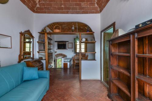 a living room with a blue couch and a kitchen at Nadine - Bilocale In Centro in Marciana