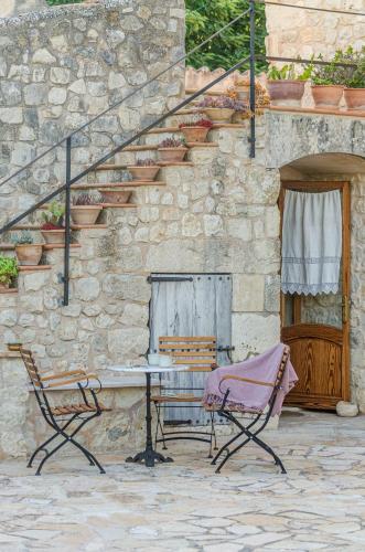 a table and two chairs in front of a stone building at Finca es Rafal, Agroturisme in Montuiri
