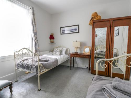 Un dormitorio con una cama y una mesa y una ventana. en Harbour Retreat, en Weymouth