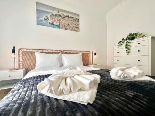 a bedroom with a large bed with two pillows at Escapada amarela SPA et détente in Mariquiteira