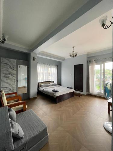 a large bedroom with a bed and a couch at Cafe Sola bnb in Shillong