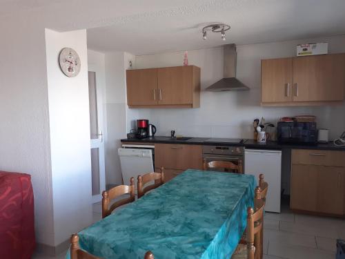 une cuisine avec une table et un chiffon vert dans l'établissement Appartement Collet d'Allevard, à Allevard