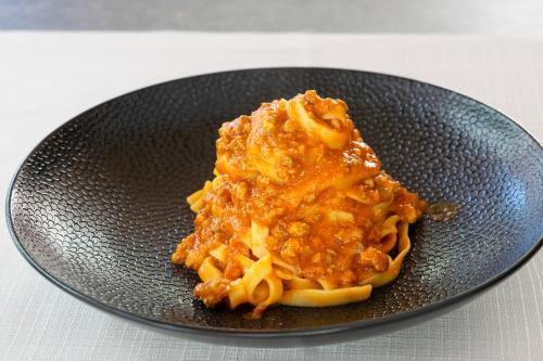 a bowl of pasta with sauce on a table at Admiral Park Hotel by Falco D'Oro Hotels in Zola Predosa