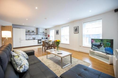 a living room with a couch and a tv and a table at Grafton Street District Apartments in Dublin