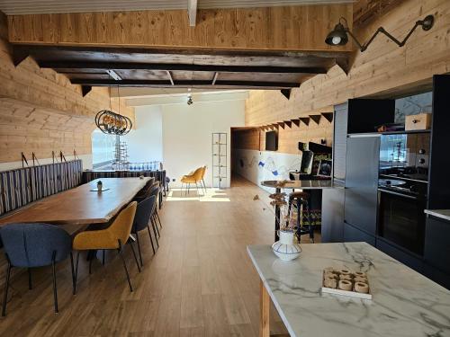 une cuisine et une salle à manger avec une table et des chaises dans l'établissement La Péniche Mathurin - Gîte insolite sur l'eau, à Saint-Omer