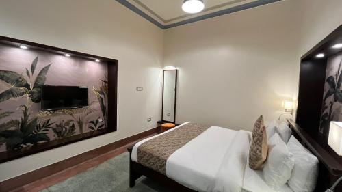 a bedroom with a bed and a flat screen tv at The Jais Boutique Stay in Varanasi