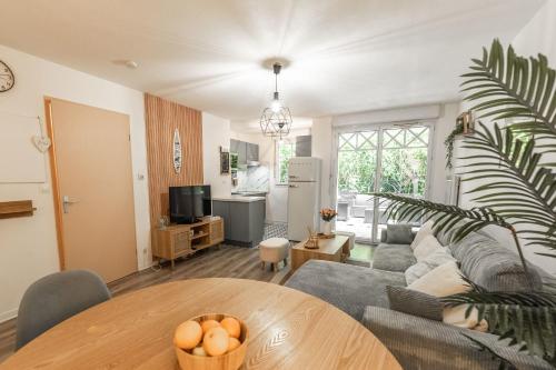 un salon avec un canapé et une table dans l'établissement Cosy apartment with terrace near Bordeaux, à Mérignac