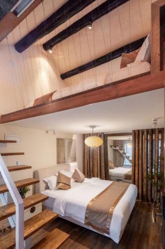 a bedroom with a large bed and a loft at Beijing Le Zai Nan Luo Gu Xiang Wang Fu Jing Forbidden City Courtyard Hotel&Free laundry service&Free coffee &Paid Dumpling experience service in Beijing