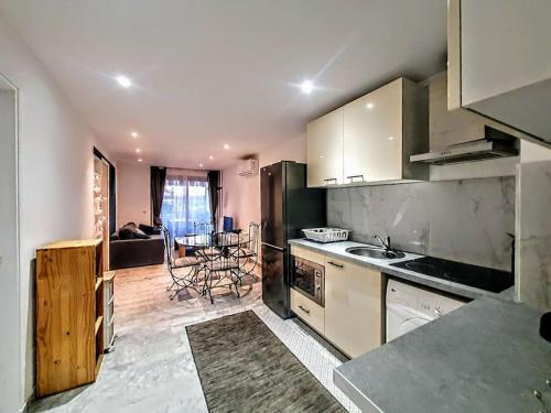 une cuisine avec un évier et une table à l'intérieur dans l'établissement 3P Mas de Tanit au calme avec piscine, à Juan-les-Pins