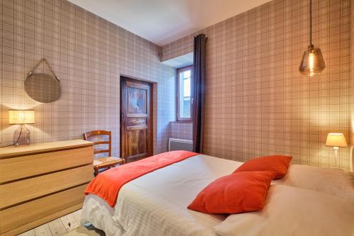 a bedroom with a bed with orange pillows on it at Jacuzzi Sauna Terrasse Venosc in Les Deux Alpes