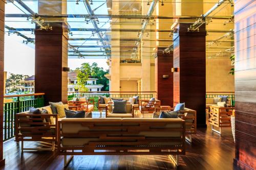 a lobby with couches and tables in a building at Savoy Seychelles Resort & Spa in Beau Vallon