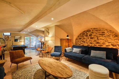 a living room with a blue couch and a stone wall at Jacuzzi Sauna Terrasse Venosc in Les Deux Alpes