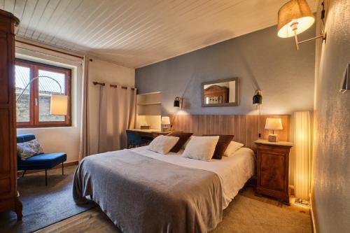 a bedroom with a bed and a chair and a mirror at Jacuzzi Sauna Terrasse Venosc in Les Deux Alpes