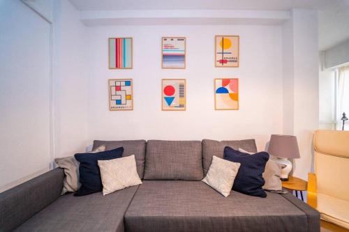 a living room with a gray couch with pillows at Authentic Alicante Central Flat near the Beach in Alicante