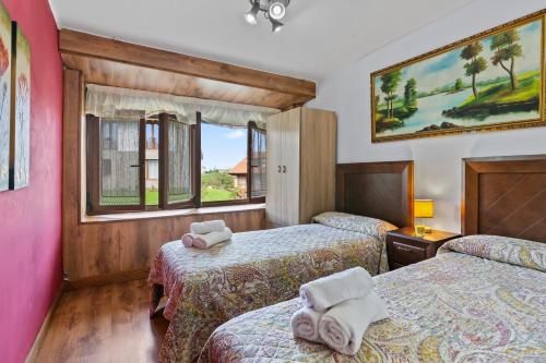 ein Hotelzimmer mit zwei Betten und einem Fenster in der Unterkunft La Casuca, entre Mar y Montaña in Udias