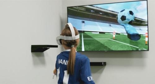 a girl is watching a soccer game on a tv at Soccer Box Pro in Dachnów