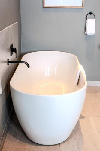 a white bath tub sitting in a bathroom at Highland Peace Haven In Dullstroom in Dullstroom