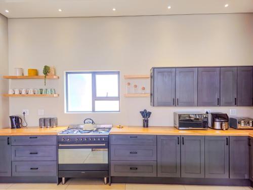 a kitchen with gray cabinets and a stove top oven at Highland Peace Haven In Dullstroom in Dullstroom