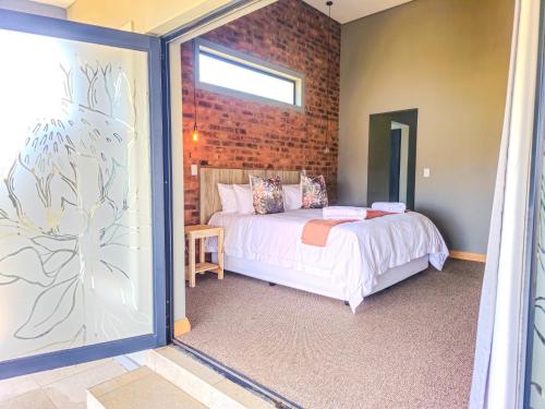 a bedroom with a bed and a brick wall at Highland Peace Haven In Dullstroom in Dullstroom